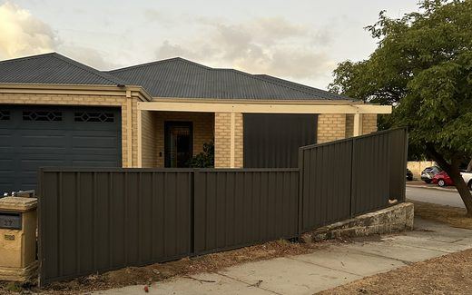 Olive-toned Colorbond fence along a driveway in front of a Perth home