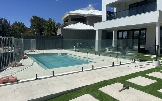 Frameless glass pool fence around a pool at a modern two-storey home