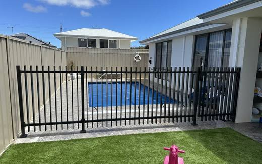 Black aluminium tubular pool fence beside a pool at a modern home