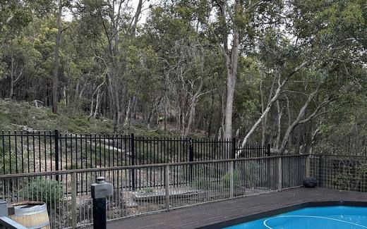 Black tubular pool fence overlooking native bushland