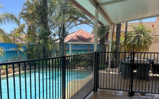 Black aluminium tubular pool fence around a paved pool and alfresco area