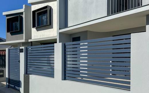Horizontal aluminium slat panels forming a modern street-front fence