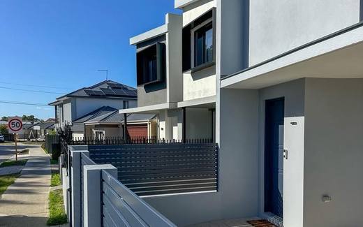Grey slat fencing with rendered piers along a modern development frontage