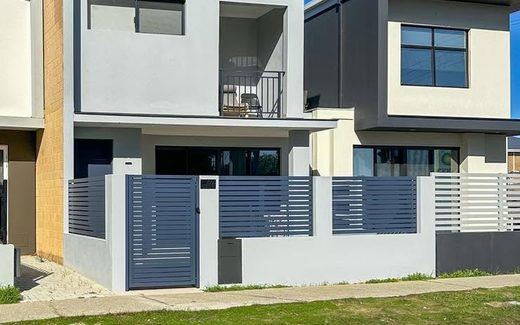 Grey aluminium slat fencing across a modern two-storey townhouse frontage