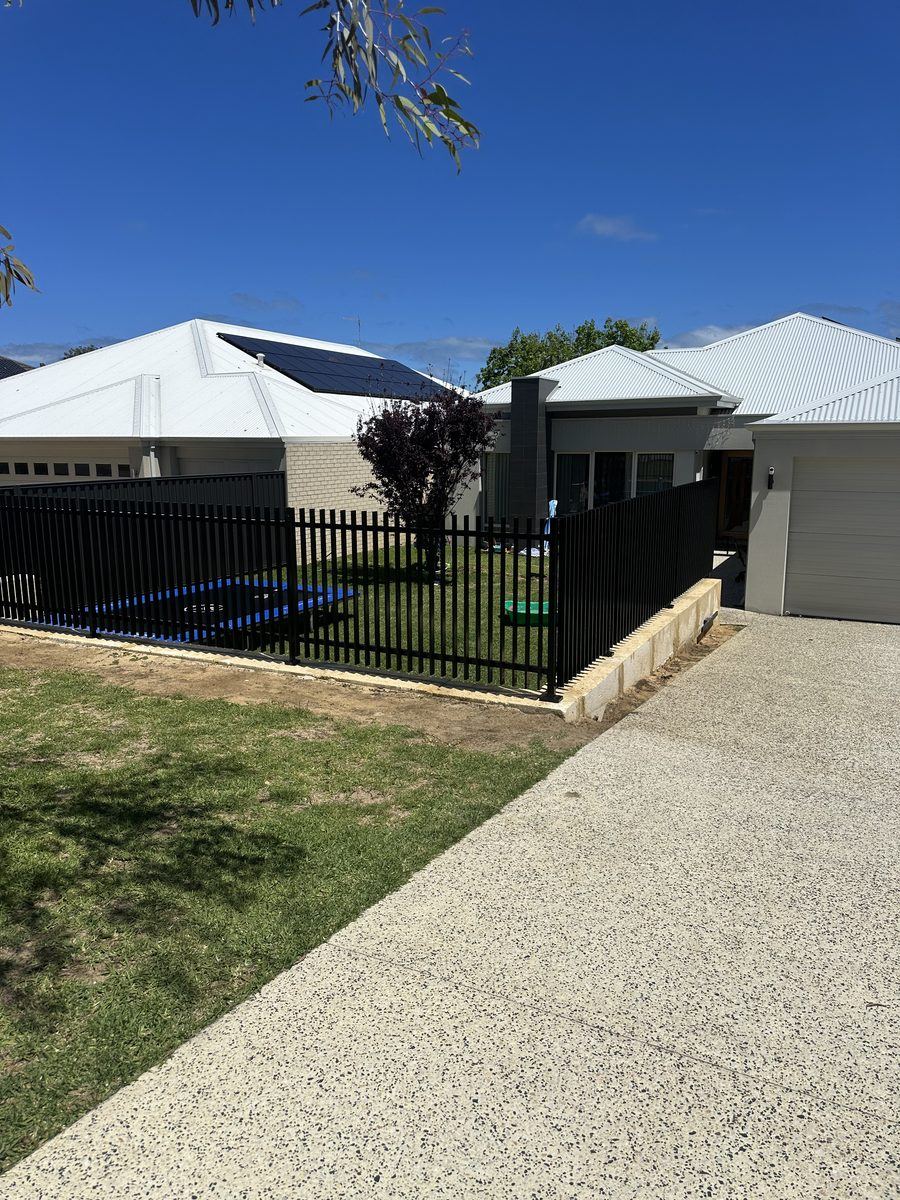 Black tubular front fencing beside a driveway and new home
