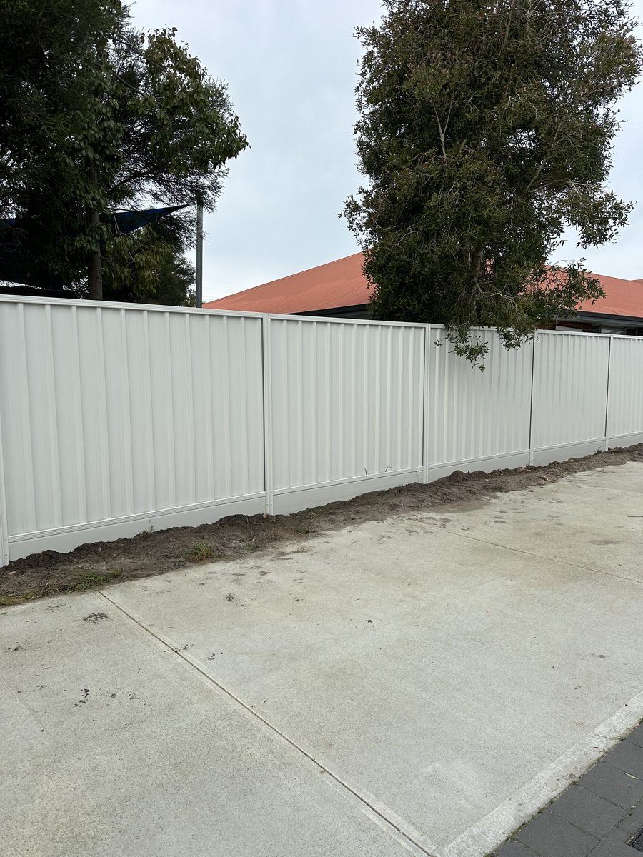 Cream Colorbond fence running the length of a concrete driveway