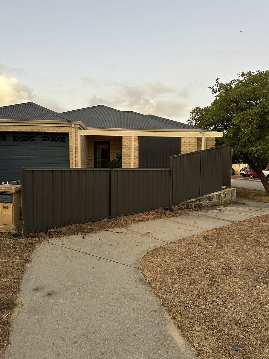 Olive-toned Colorbond fence along a driveway in front of a Perth home