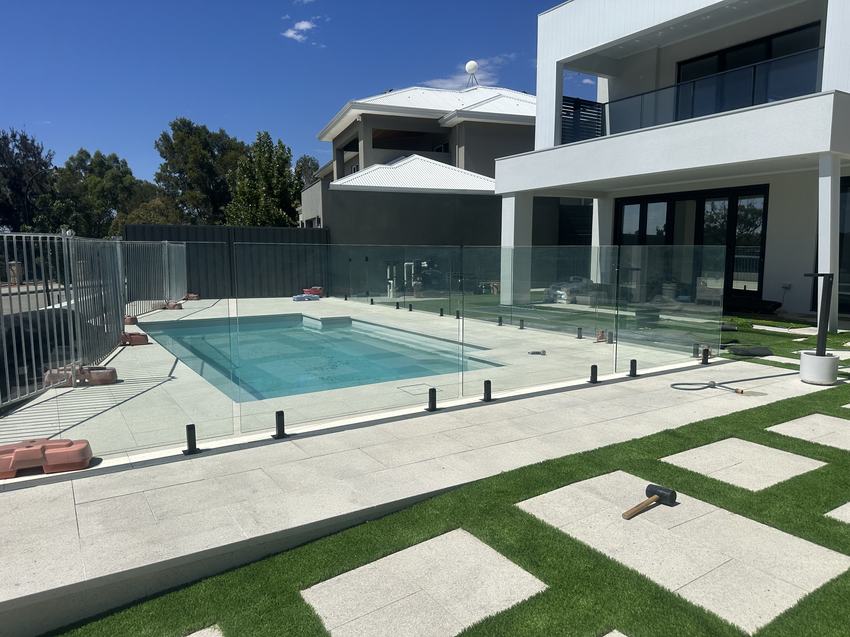 Frameless glass pool fence around a pool at a modern two-storey home