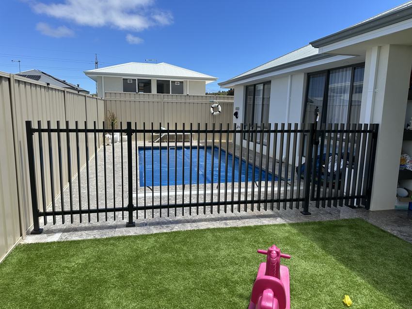 Black aluminium tubular pool fence beside a pool at a modern home