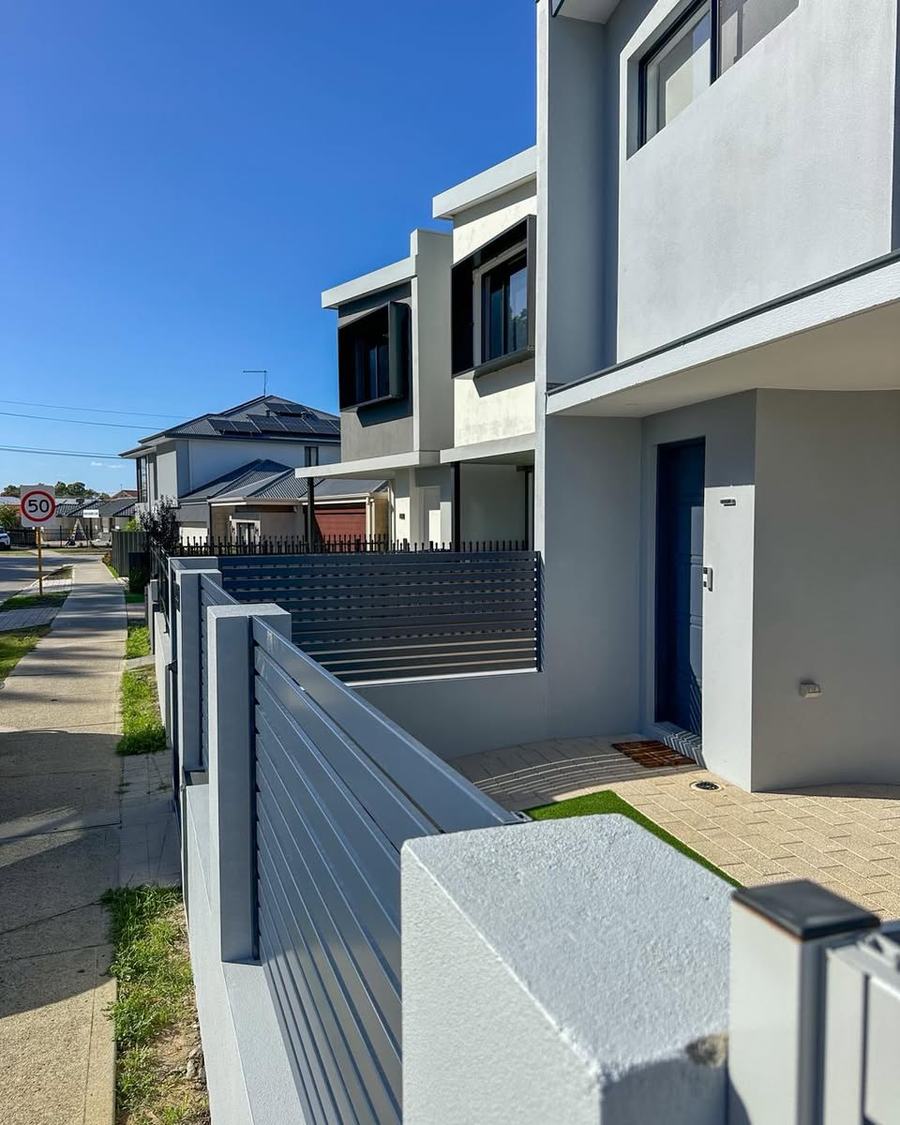 Grey slat fencing with rendered piers along a modern development frontage