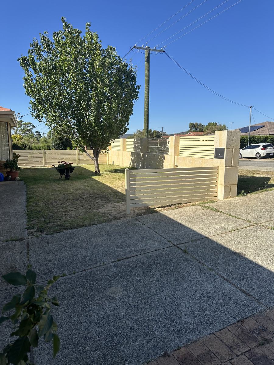 Cream aluminium slat screening set between rendered pillars at a front boundary